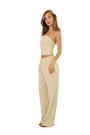 A woman modeling a beige two-piece set consisting of a strapless crop top and matching wide-leg pants, photographed against a seamless white studio background.